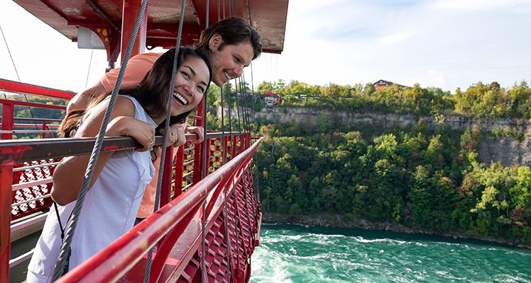 man and woman on a red cable car
