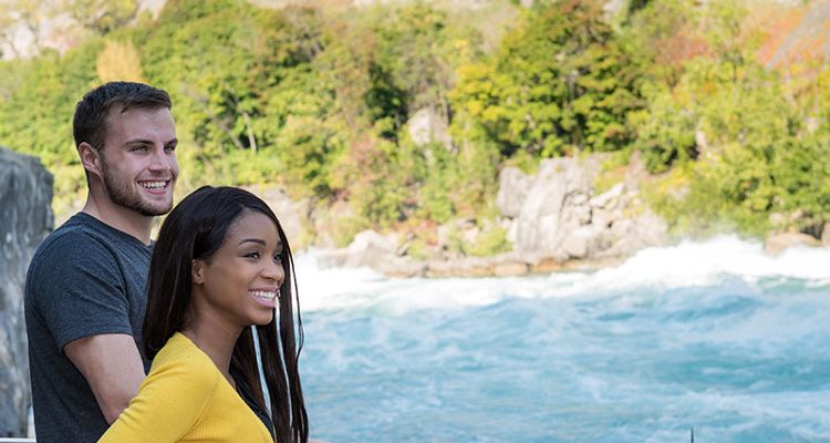 Man and woman enjoy view of whitewater rapids
