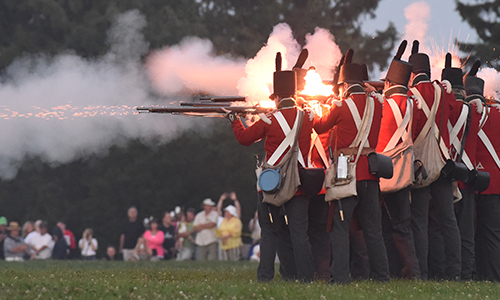 Soldiers firing muskets in a line