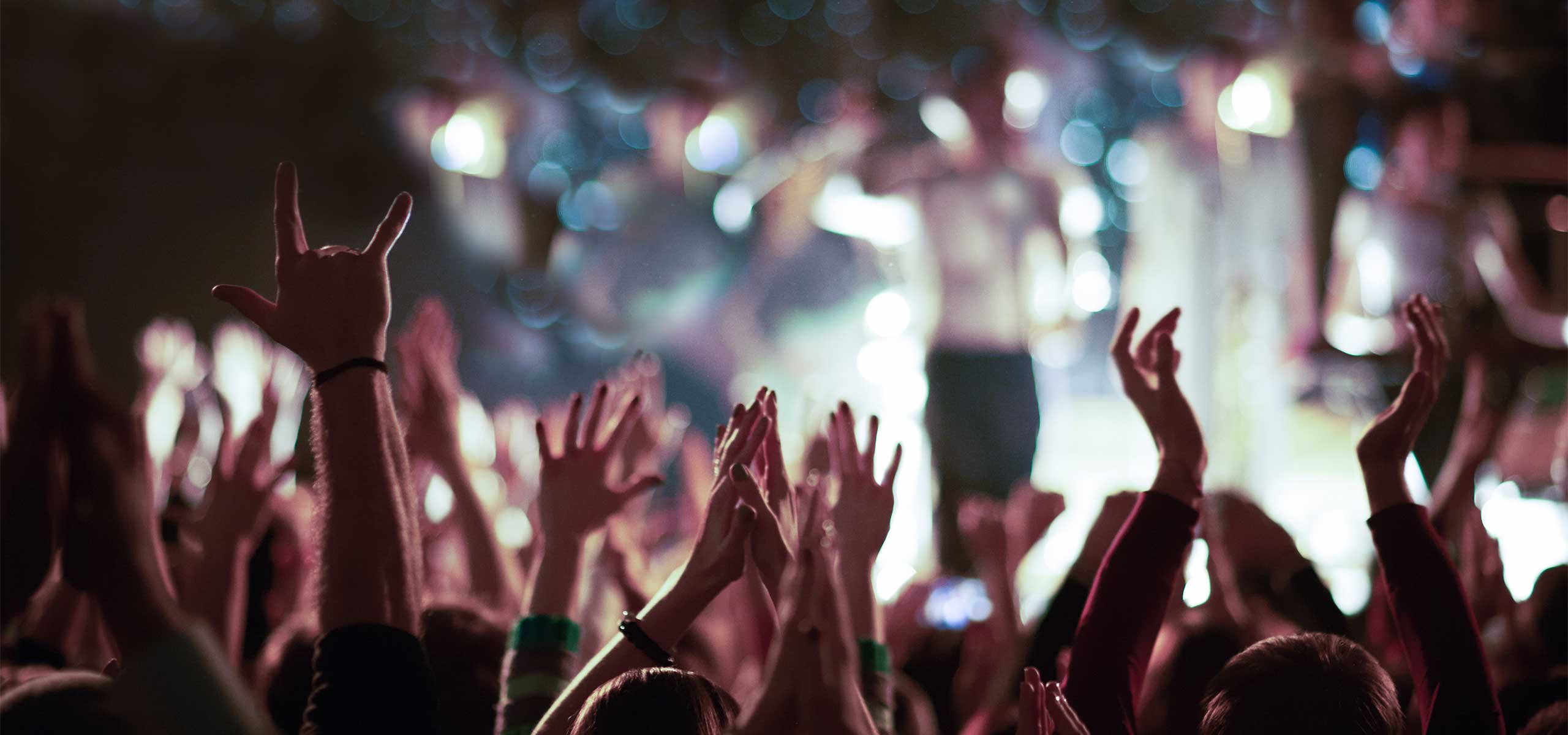 A band crowd waving during a concert