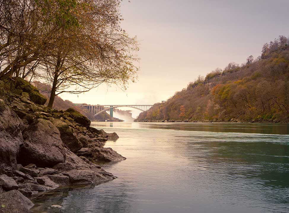 An evening view of the Rainbow Bridge from the Niagara Glen River